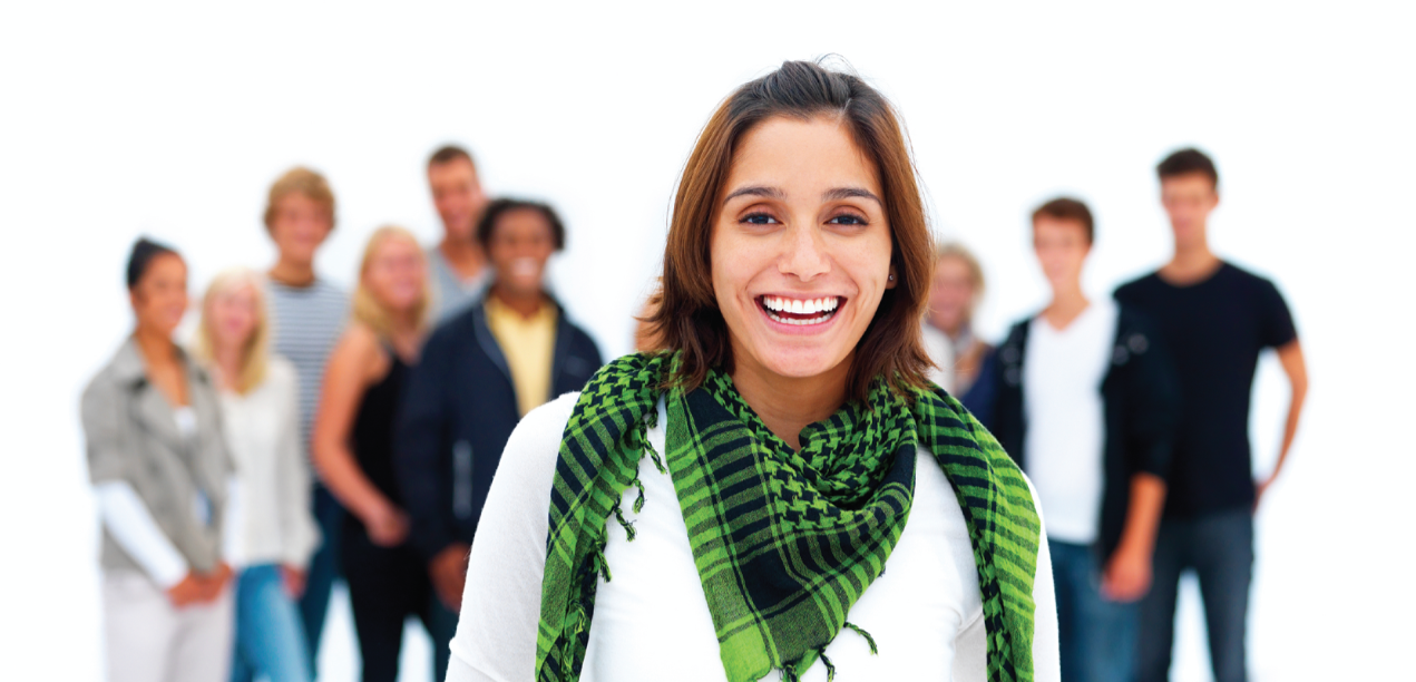 Woman in front smiling with blurred group of people behind her.